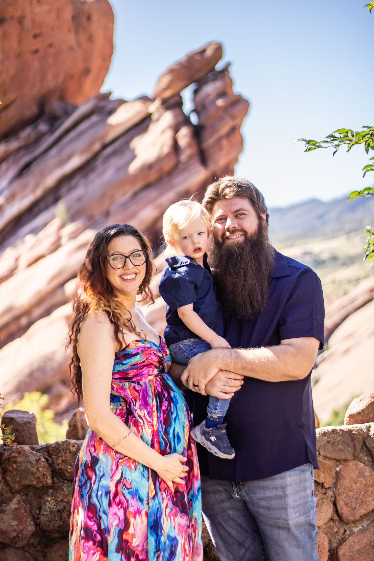 A couple shares a joyful moment together against red rock formations at a scenic overlook.