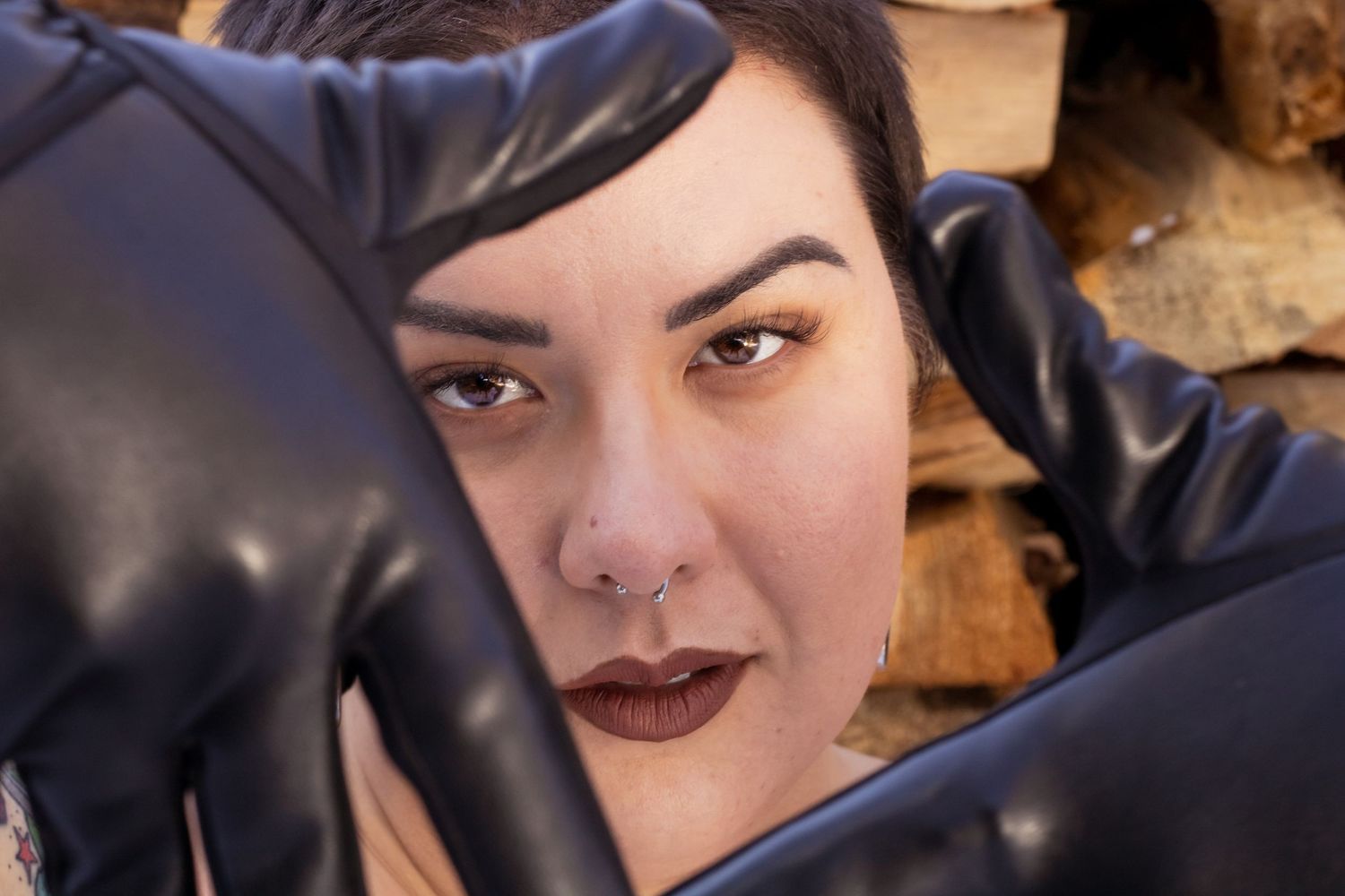 A person with dark lipstick and dramatic eye makeup poses for a close-up selfie shot.