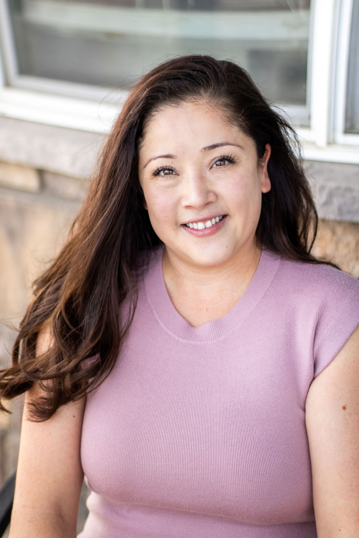 A woman in a lavender sleeveless top smiles warmly in a series of headshots with natural lighting.