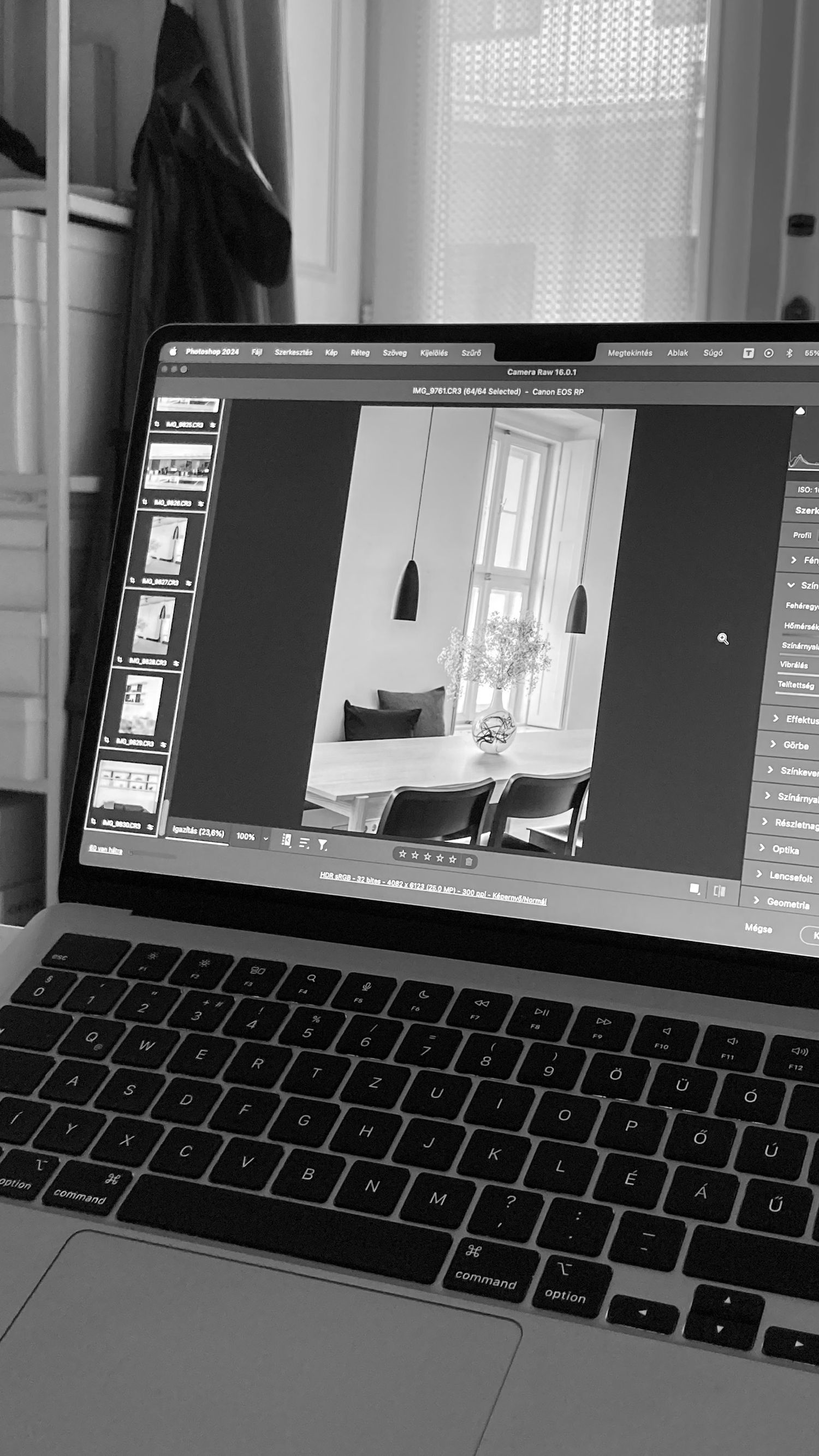 Black and white photo of a MacBook displaying interior photography in Adobe Photoshop editing software.