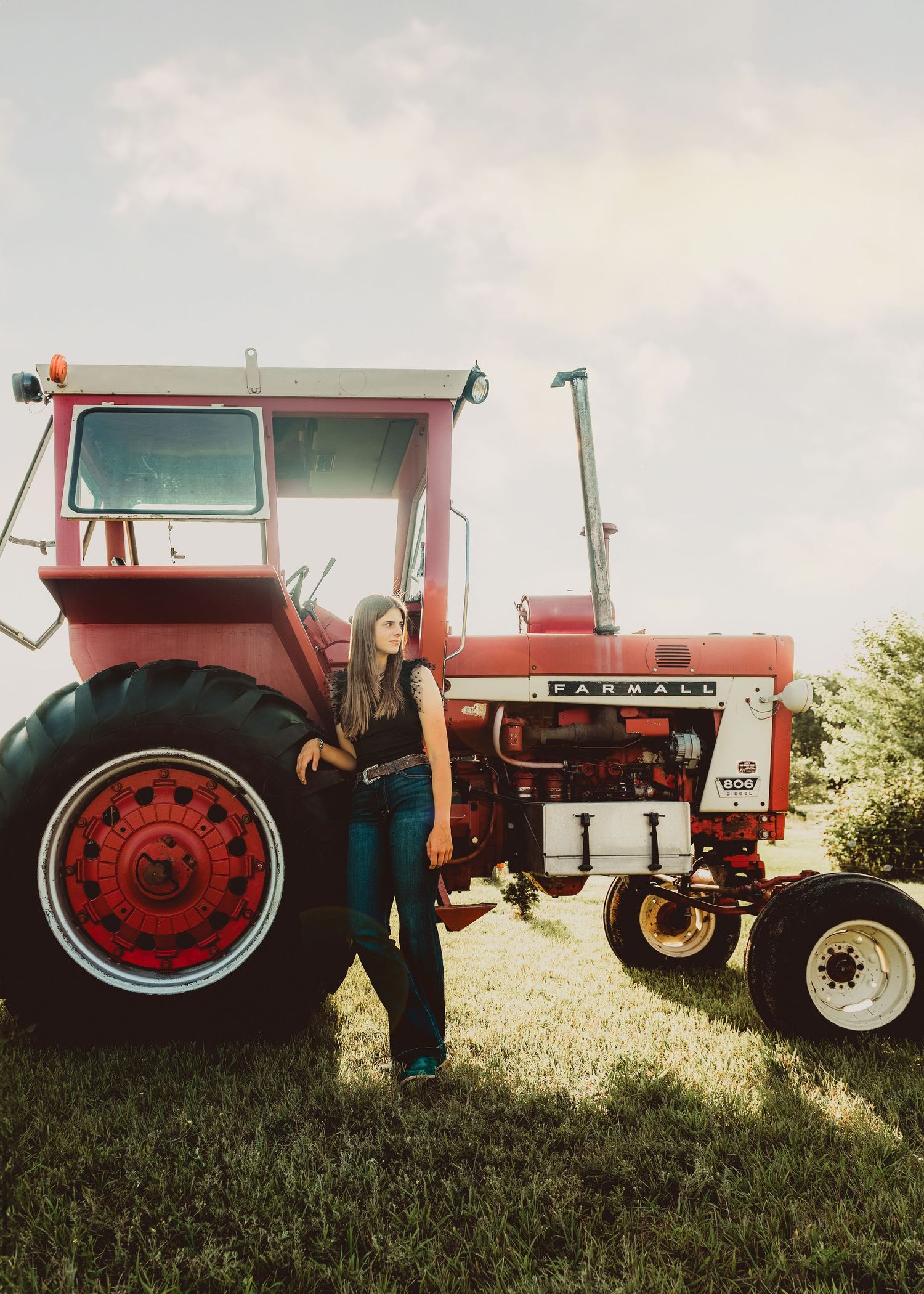 A lineup of vintage red International Harvester tractors displayed on grassy field showcasing agricultural heritage.