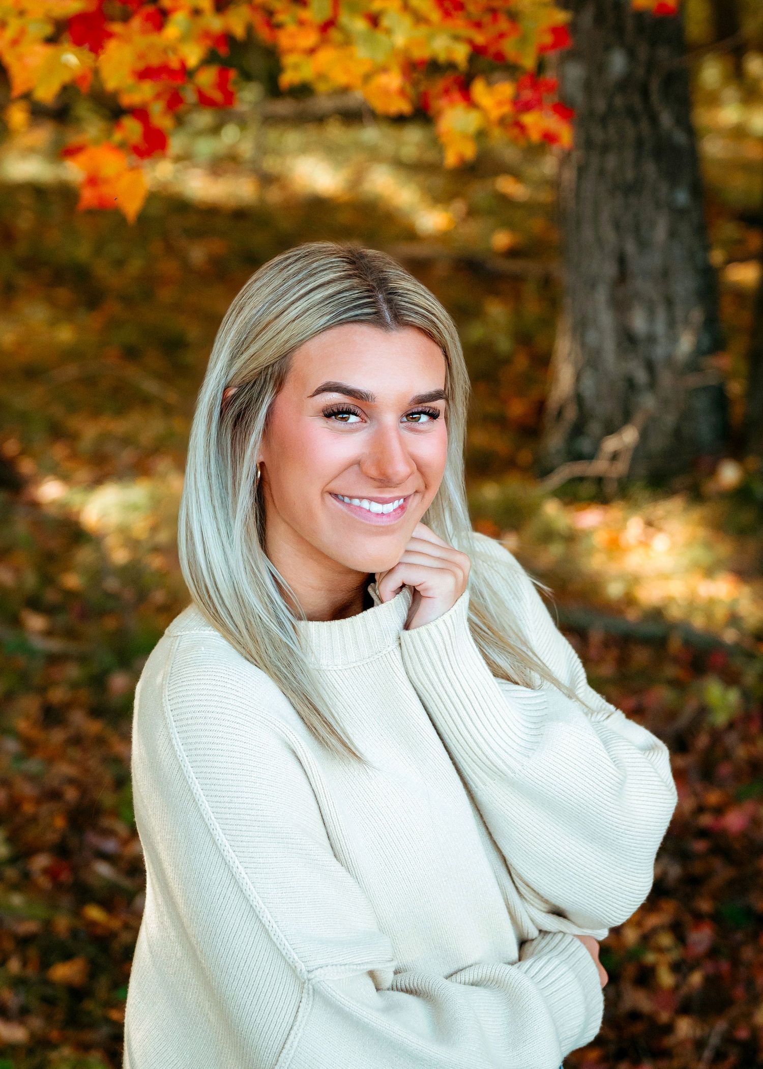 Winter fashion portraits featuring person in white sweater amid fall foliage.