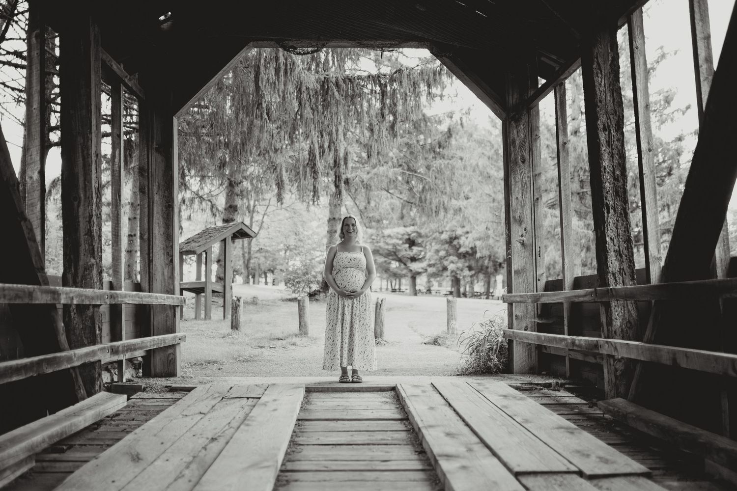 A series of five black and white photographs showing covered wooden bridges in a rustic, rural setting.