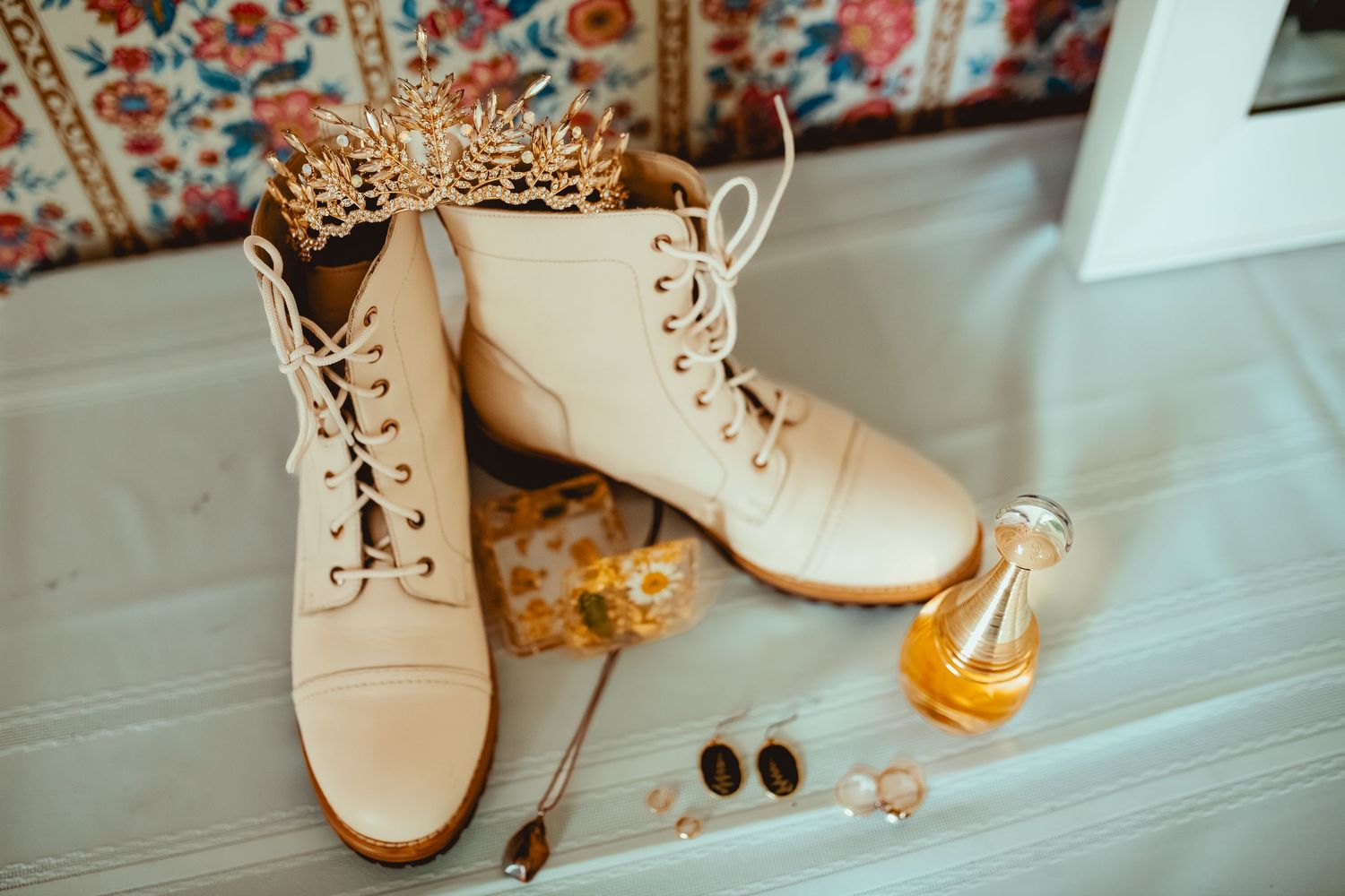 Beige suede oxford shoes with brown laces arranged in a row on a light wooden surface.
