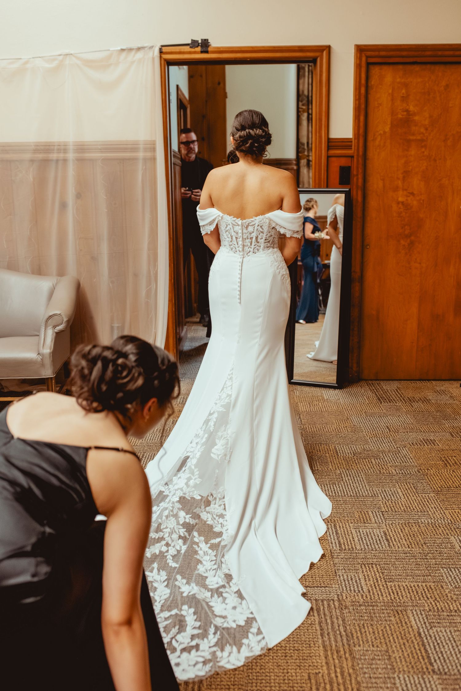 A wedding dress with intricate lace details and a flowing train is showcased from different angles.