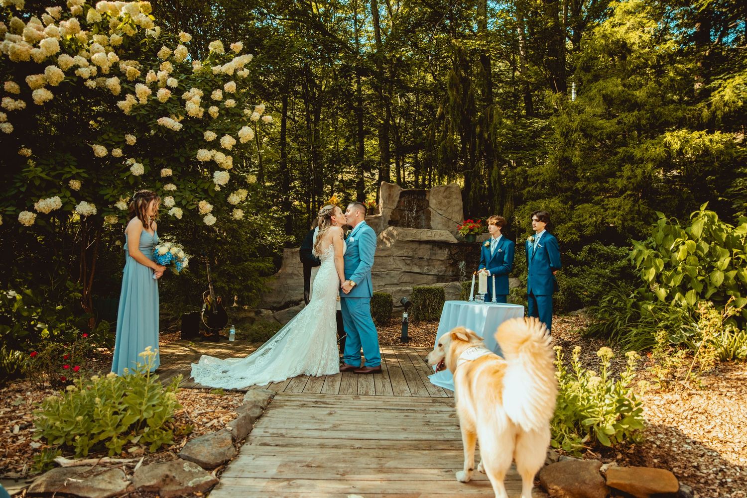 Wedding ceremony setup in a lush garden with turquoise and white decor elements.