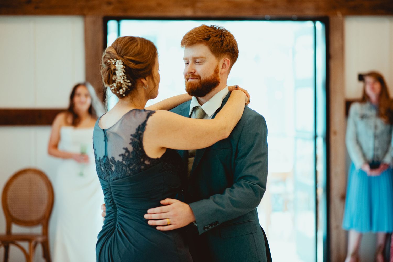Couples sharing romantic slow dances at an indoor wedding reception.