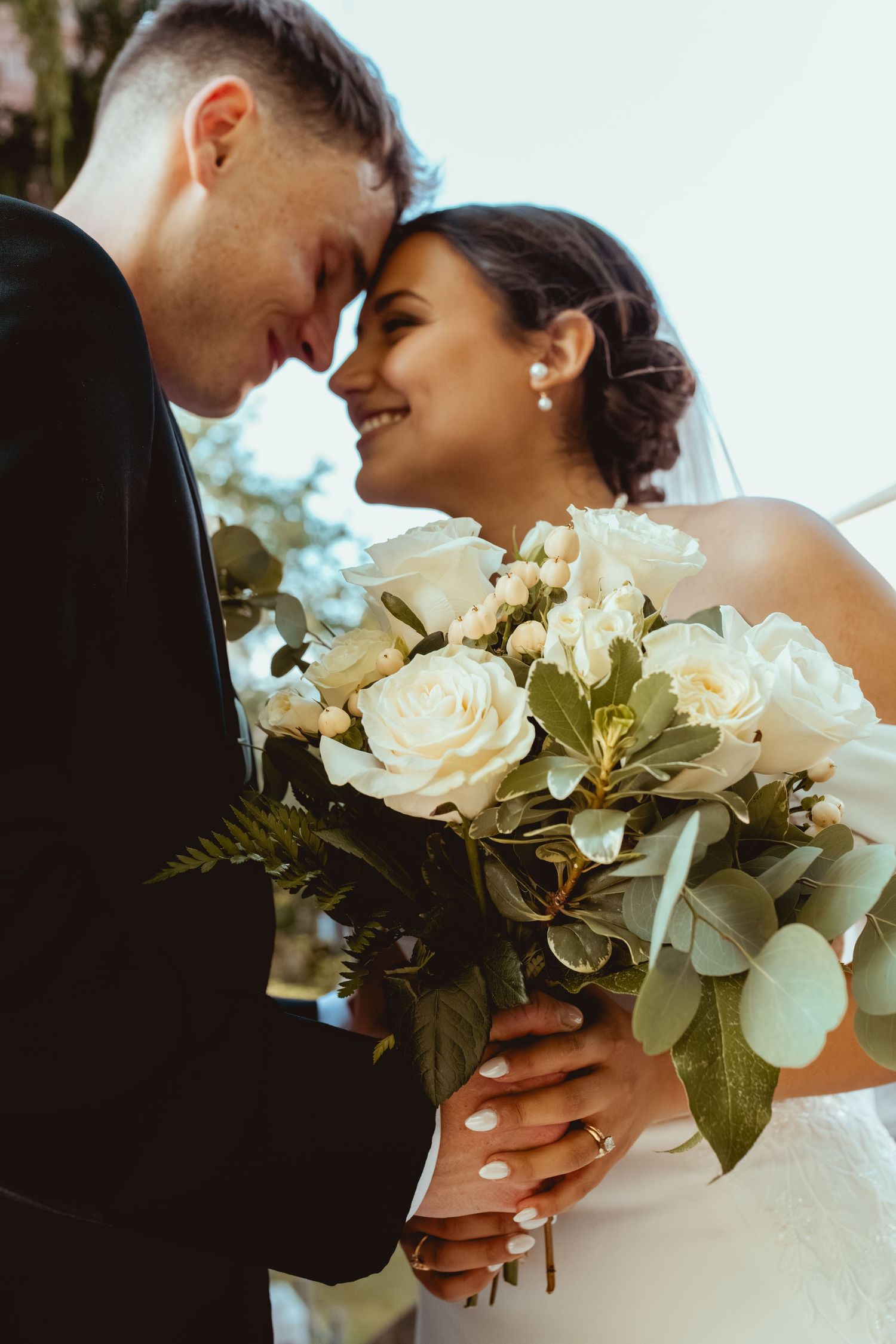 Romantic wedding portraits featuring white rose bouquets and intimate close-up moments.