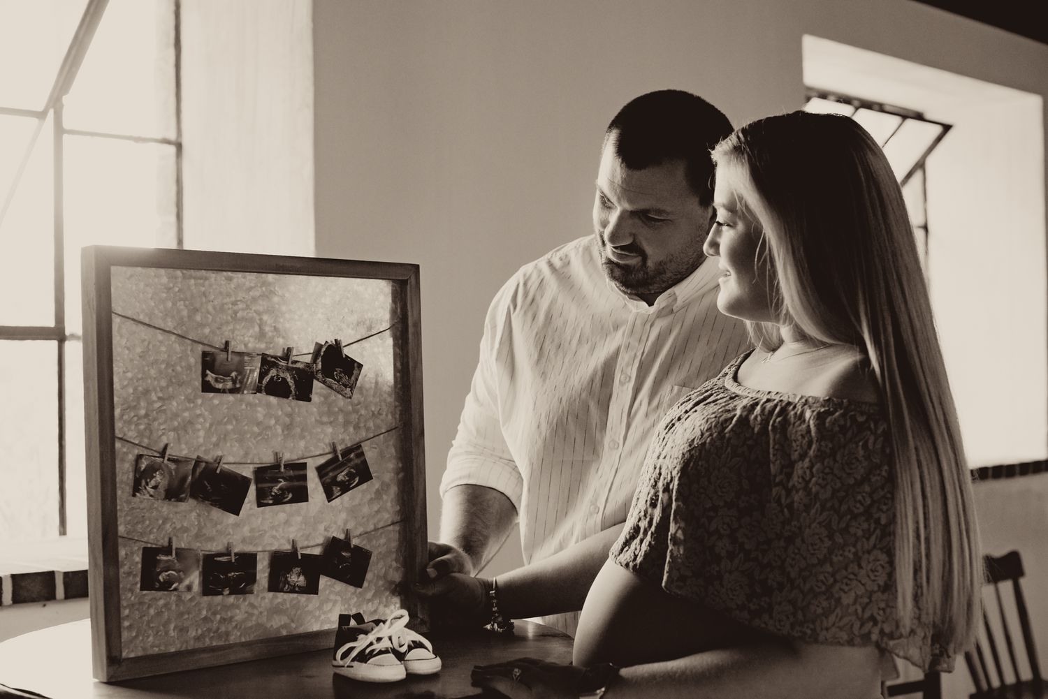 Black and white film photographs displayed on a wall in a gallery-style arrangement.