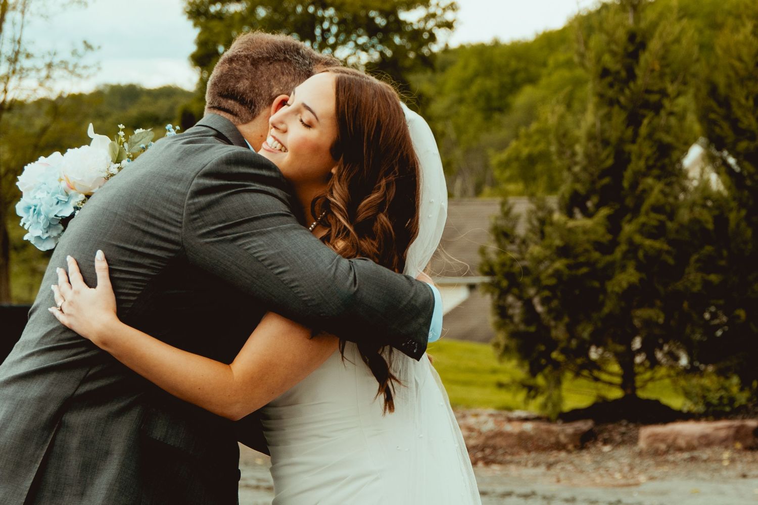 Wedding party embracing and sharing emotional moments in a scenic outdoor setting.