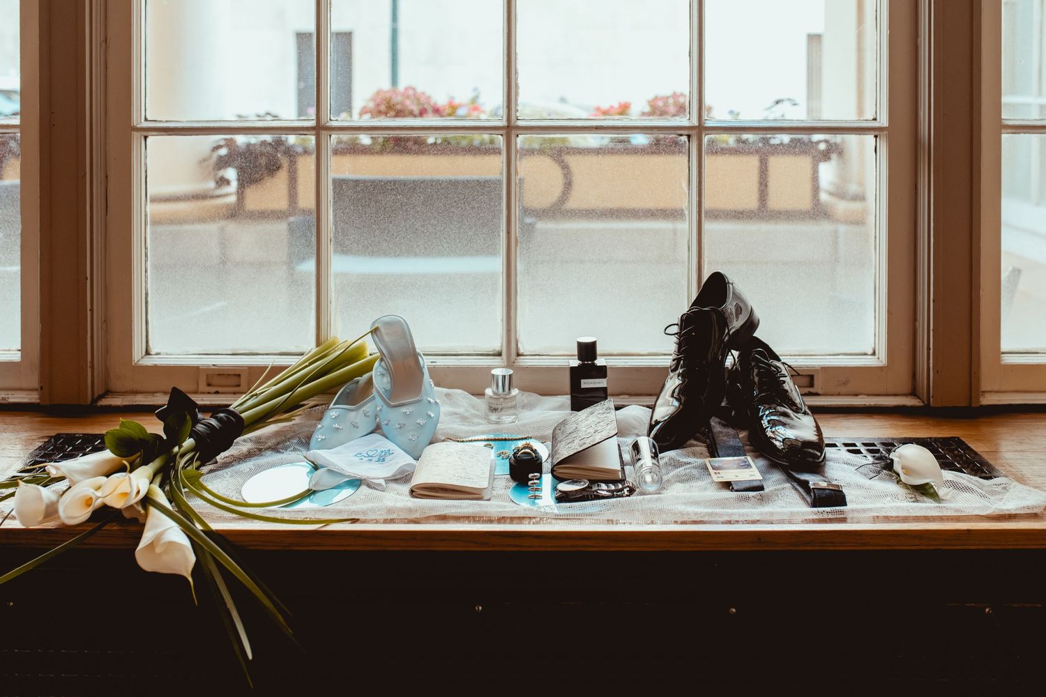 A row of windows with silhouetted objects and equipment on the windowsill against natural daylight.