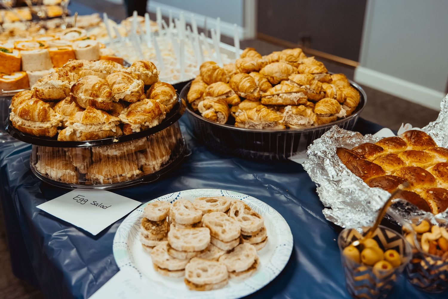 An assortment of freshly baked pastries and cookies displayed on plates and serving trays at a bakery counter.