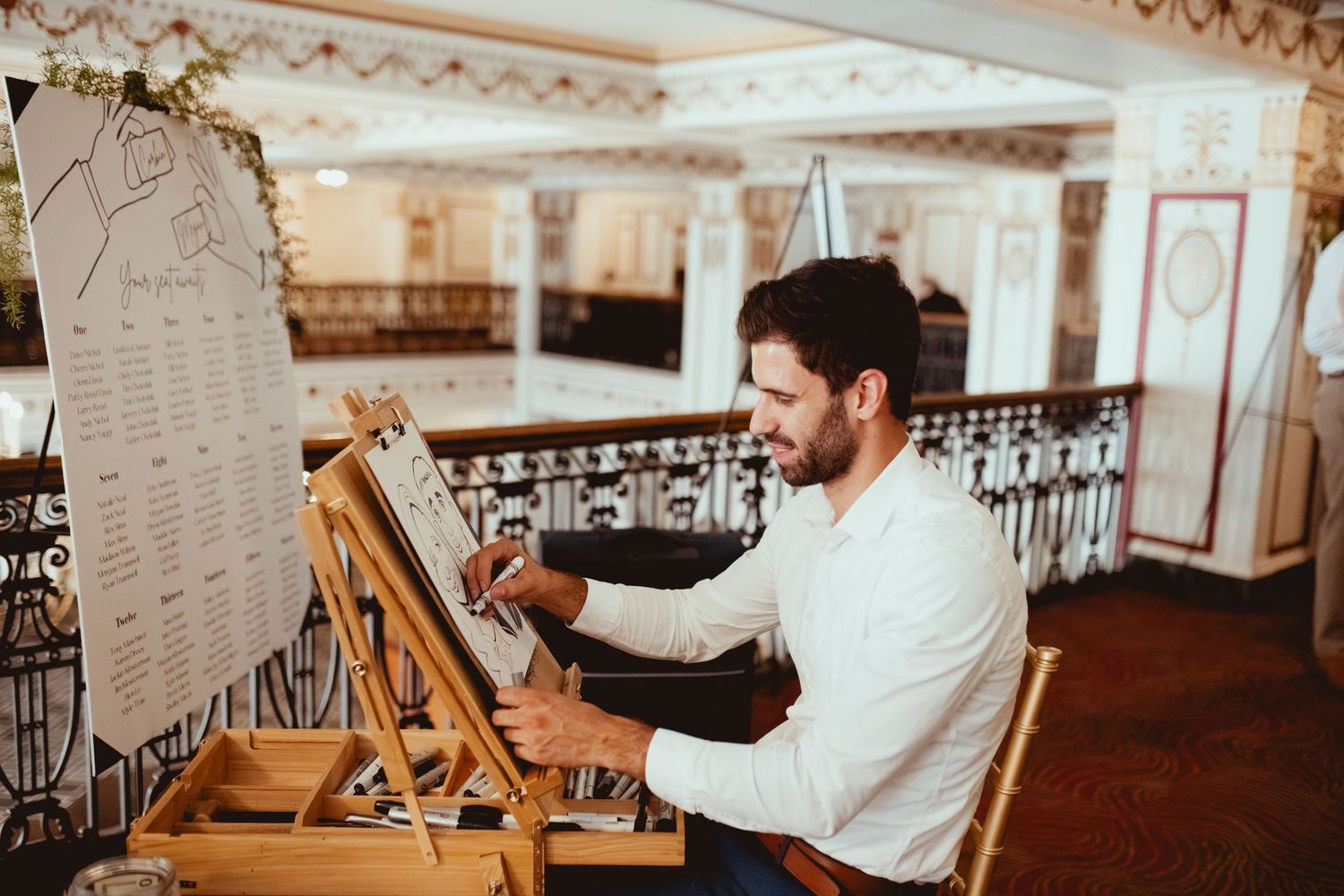 Wedding guests hold up handmade signs during a celebration in an elegant venue.