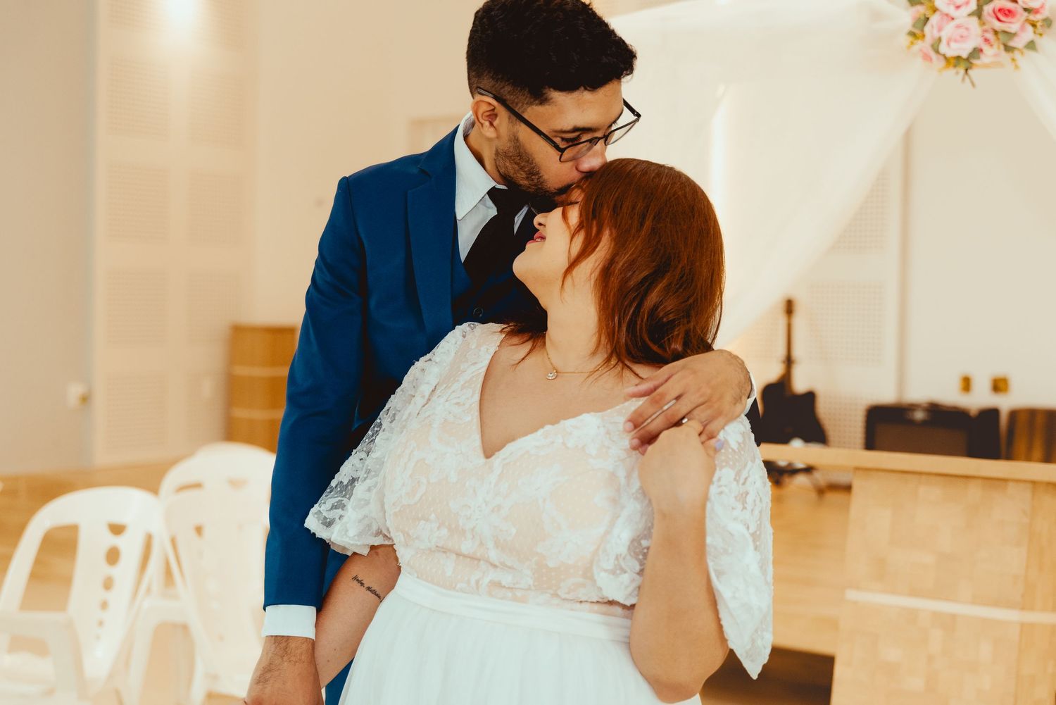 A couple shares a romantic first dance in an elegant white wedding reception venue.