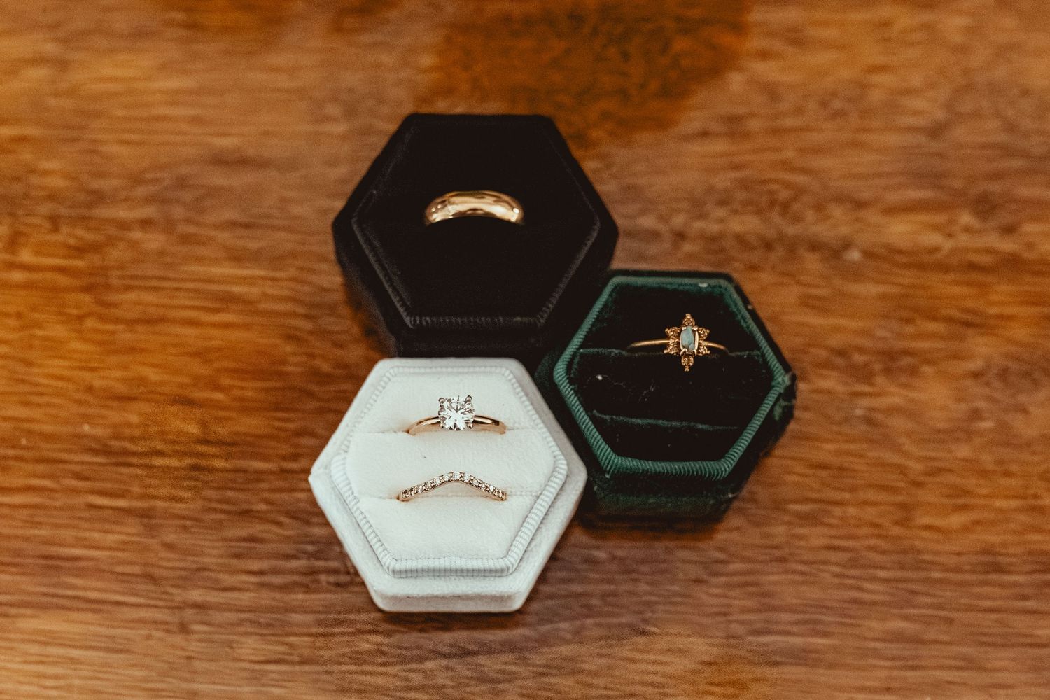 A series of small hexagonal jewelry boxes arranged in a row on a wooden surface showing different angles and positions.