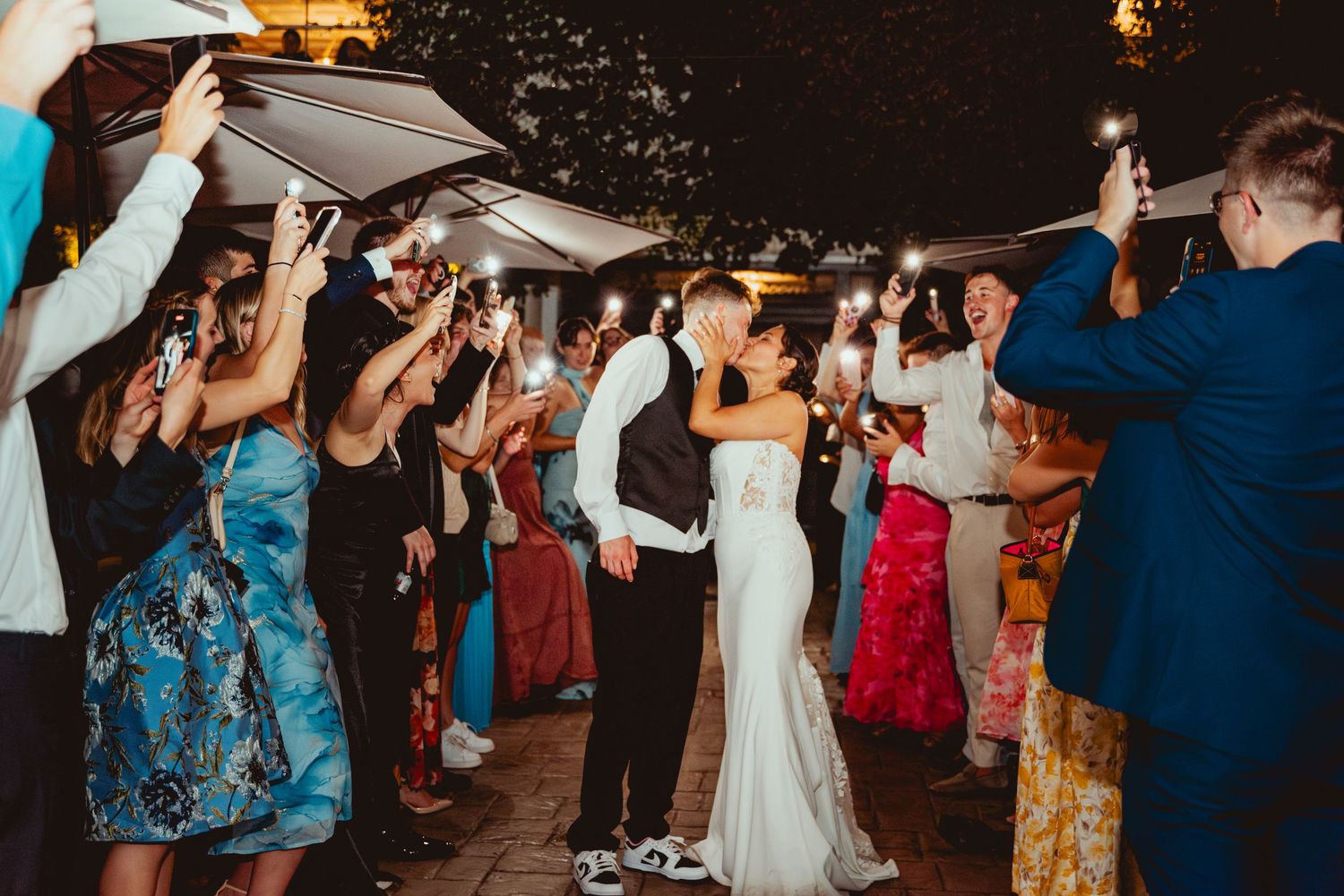 Wedding reception dance floor filled with guests celebrating under evening lighting.