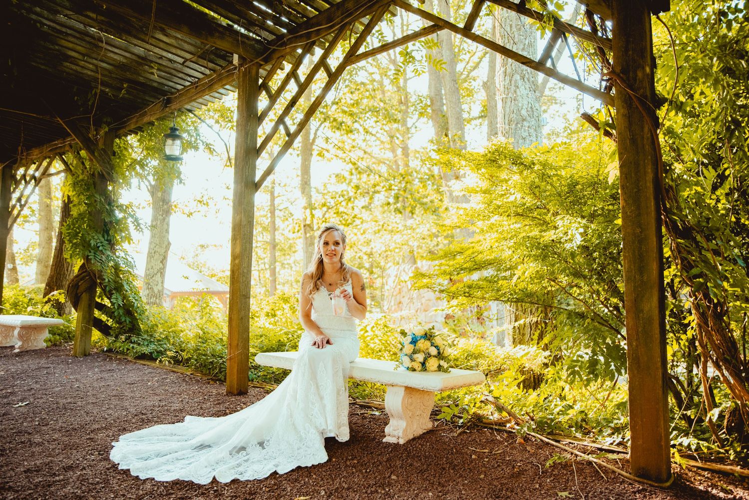 Elegant bridal portraits under a wooden pergola with sunlit trees in the background.
