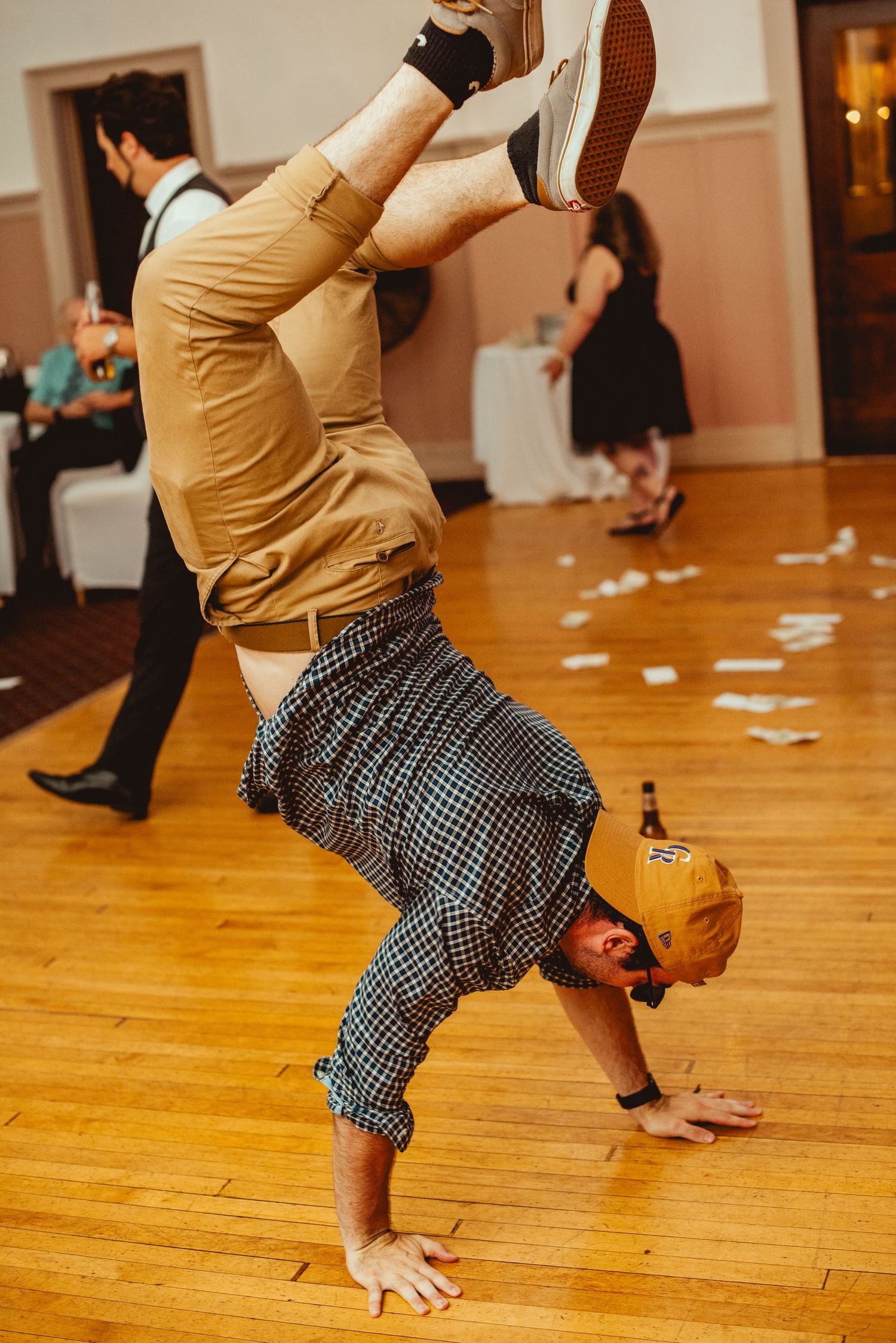 Energetic dance moves on a wooden floor during a wedding reception celebration.