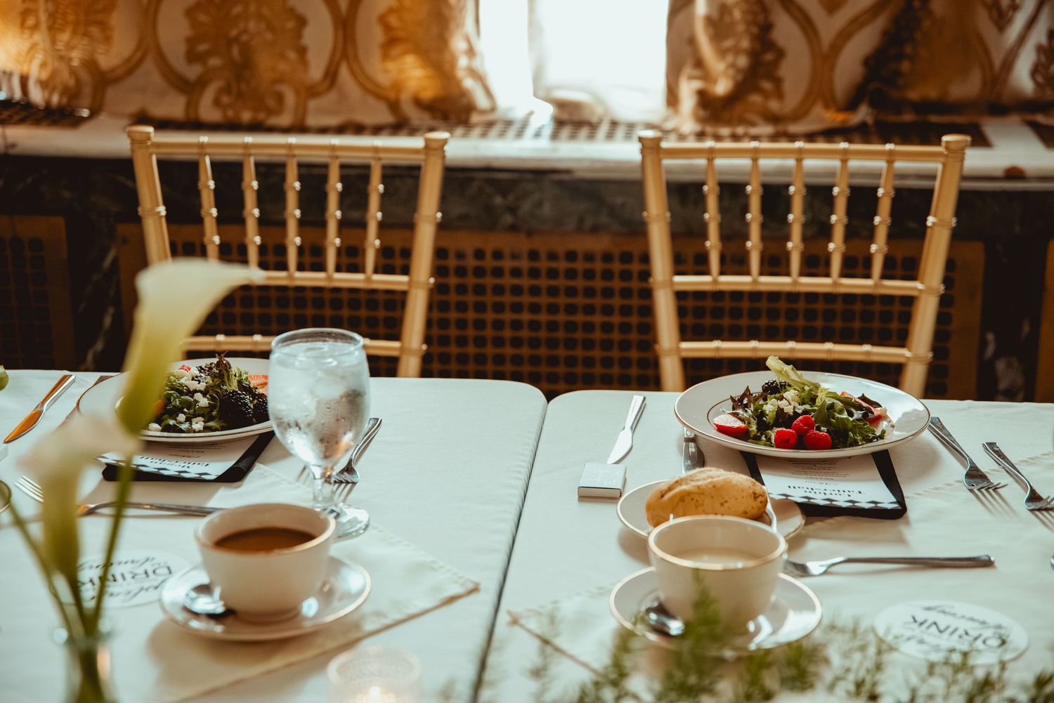 Elegant table setting with teacups and floral arrangements at wedding reception.