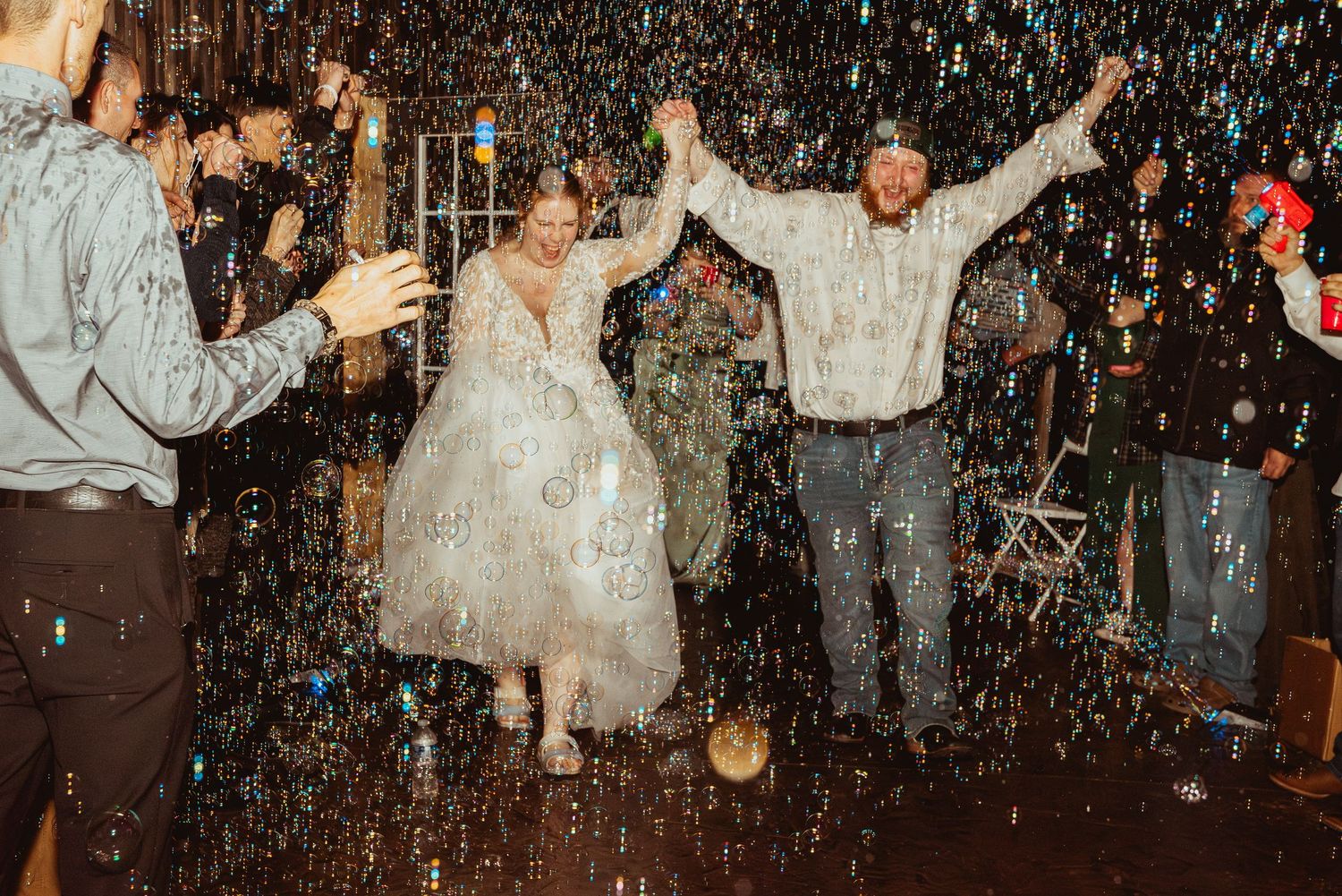 Wedding celebration scene with confetti falling as people dance and celebrate in a dimly lit indoor venue.