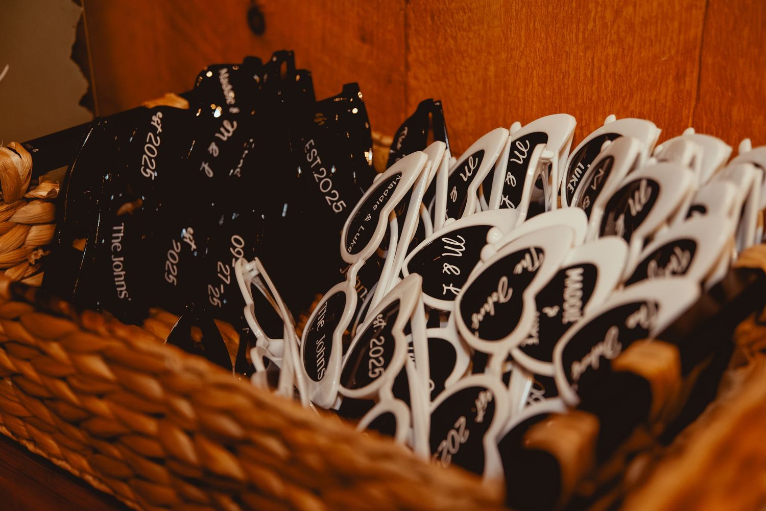 Row of black and white patterned napkins arranged on wooden tables at rustic wedding reception.