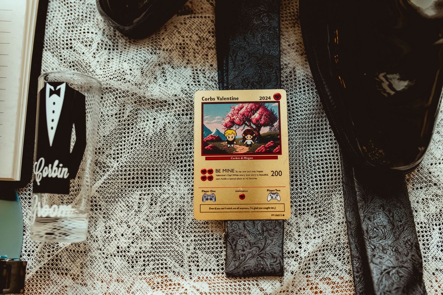 A Pokémon trading card and formal attire displayed on white lace fabric.