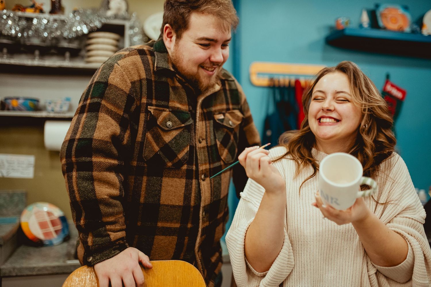 Couple enjoying coffee together at a cafe table while sharing warm smiles and conversation.