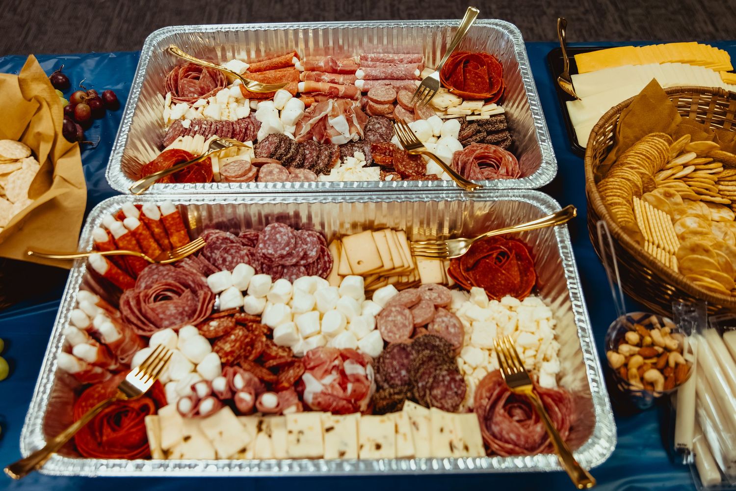 Long catering tray filled with assorted meats and cheese arranged for a buffet service.