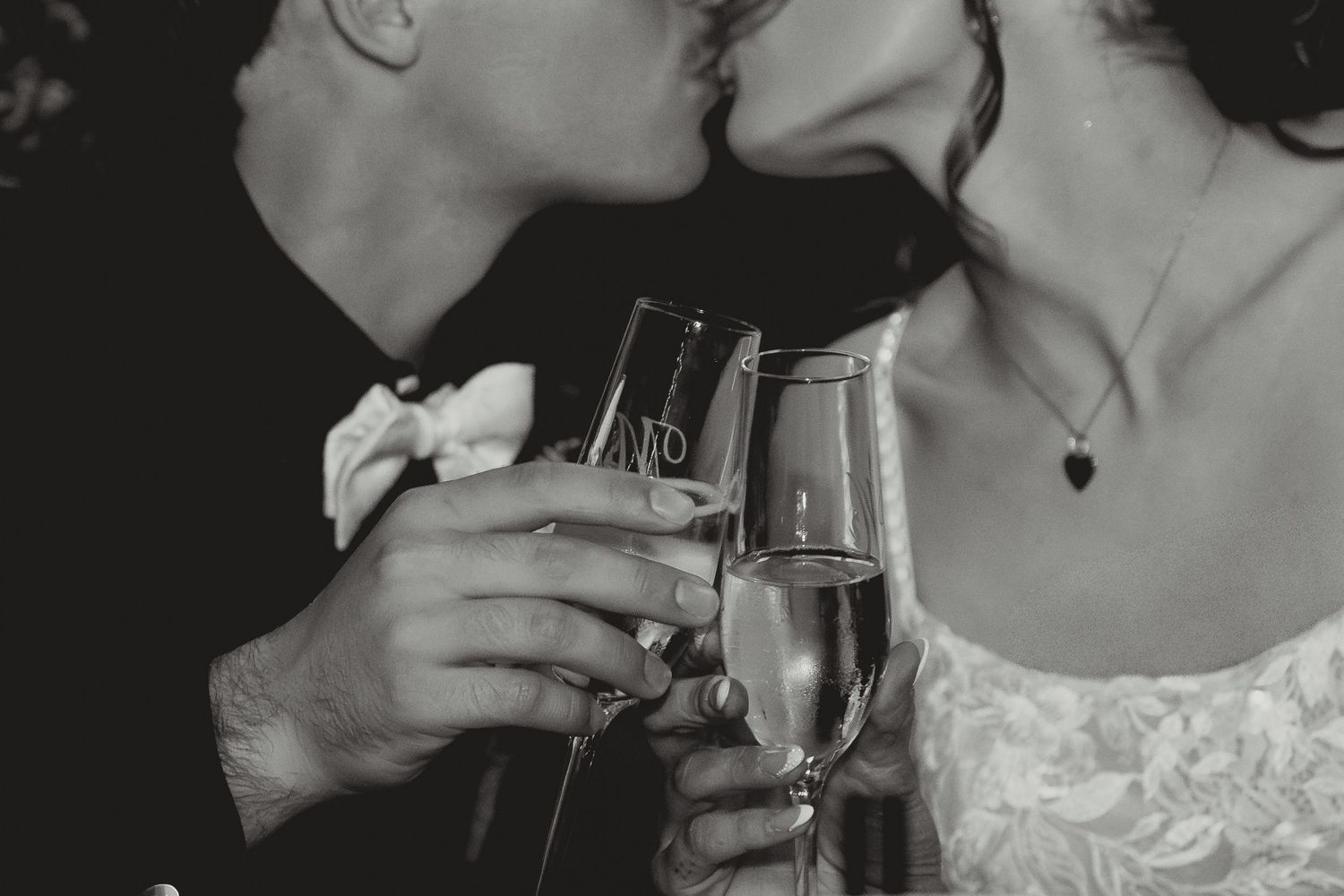 Black and white close-up shots of wedding couple sharing intimate moments with champagne glasses.