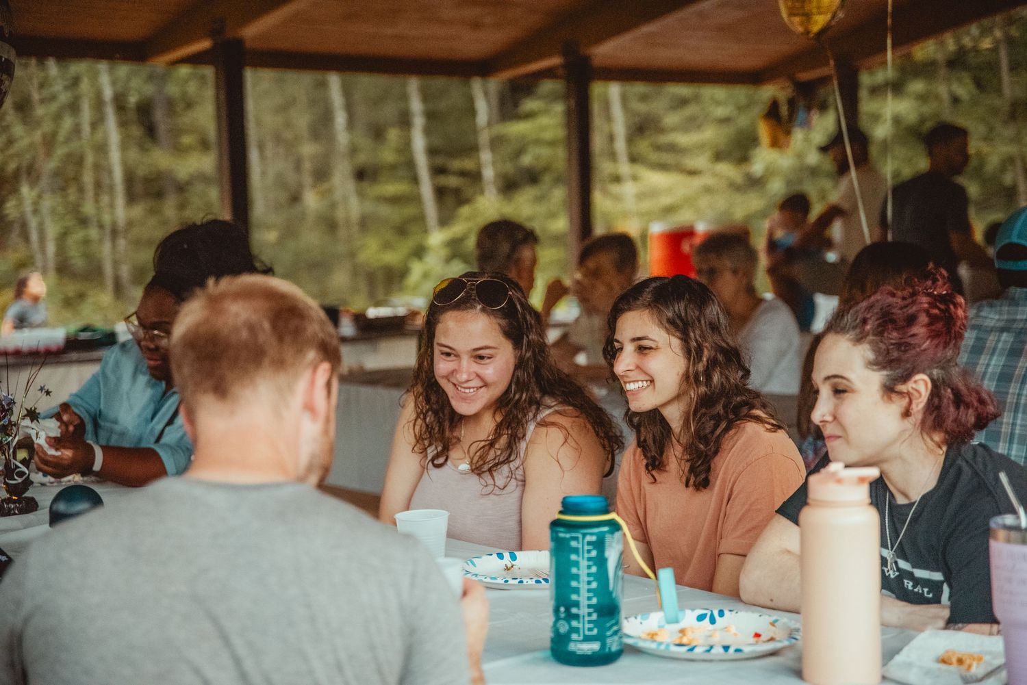 People gathered under a covered pavilion or shelter for a social event or gathering.