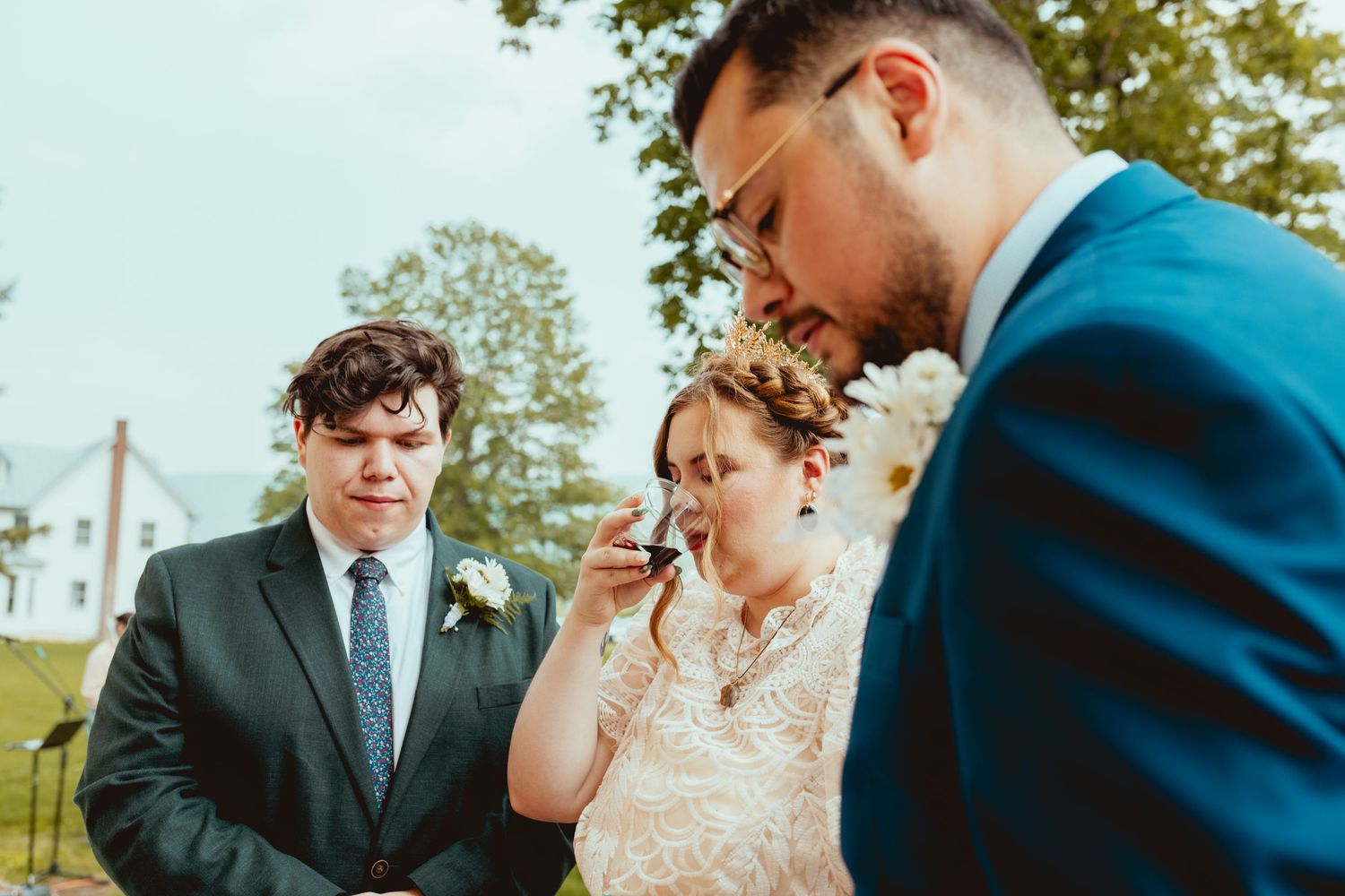 Guests sharing emotional moments during an outdoor wedding ceremony with greenery in the background.