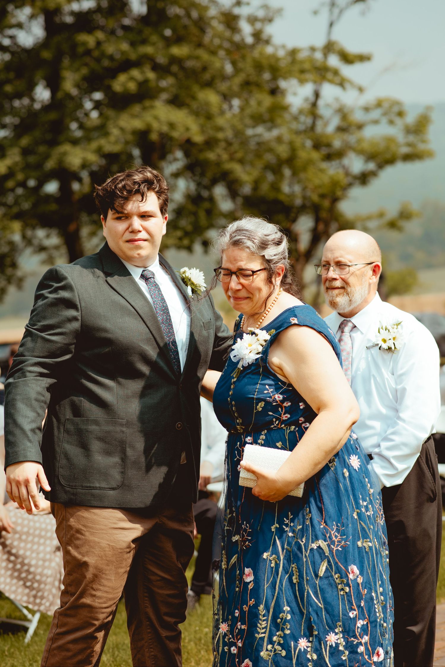 A sequence of candid moments at an outdoor wedding reception showing guests in formal attire interacting on a sunny day.