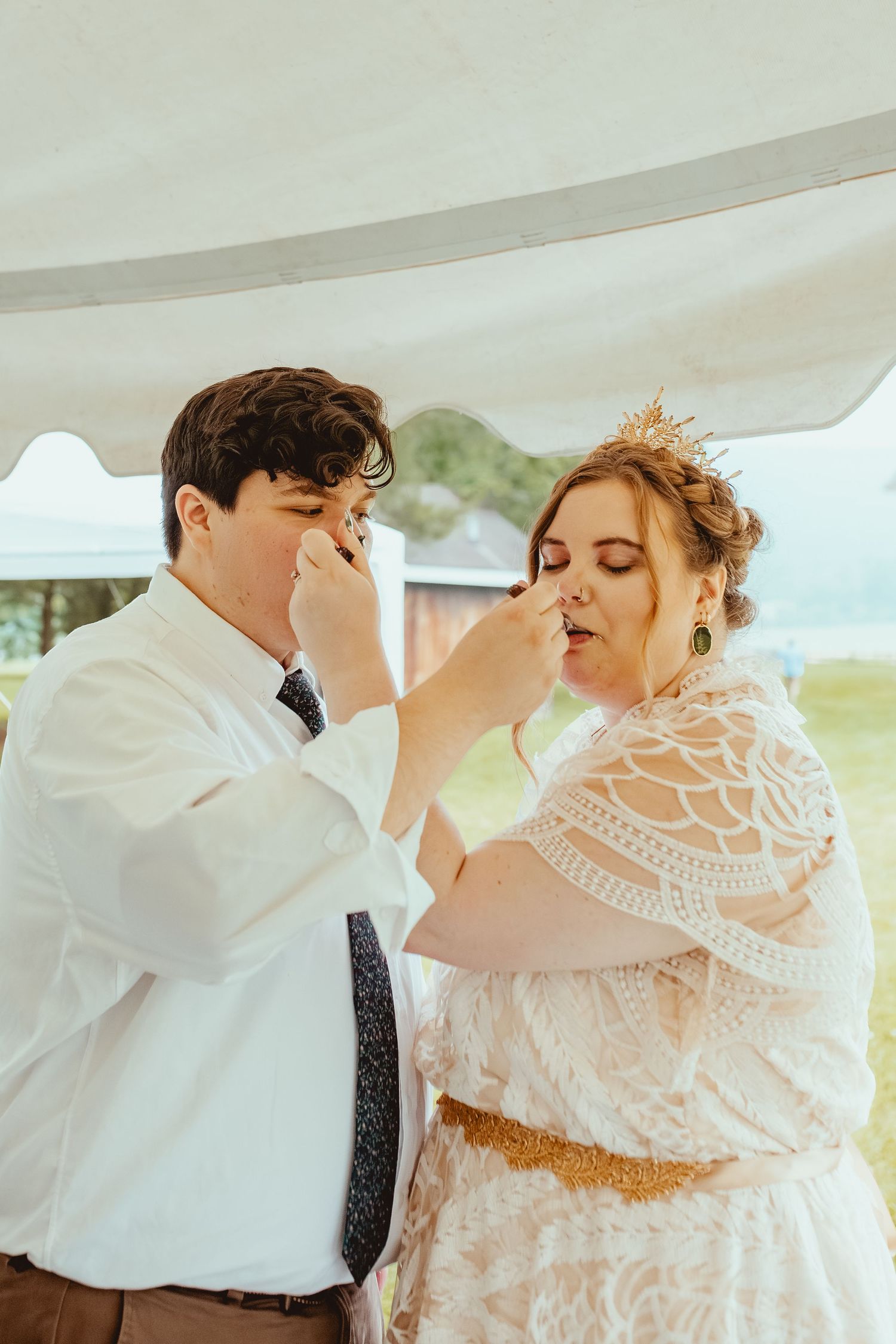 A couple participates in the traditional wedding cake feeding ritual during their reception celebration.