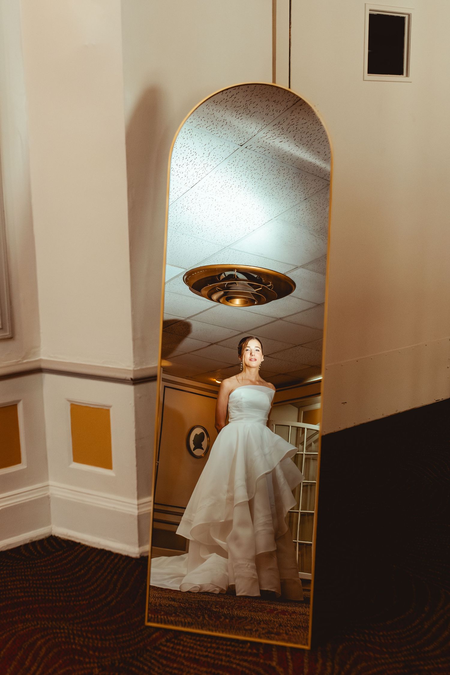 Series of photos showing a ghostly white wedding dress floating through a dimly lit hallway in an elegant venue.