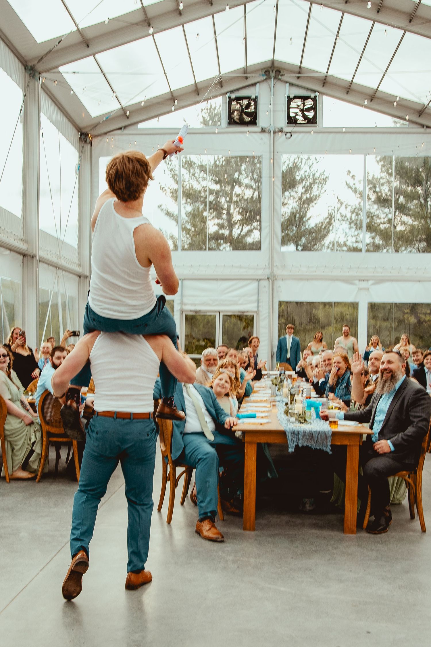 Energetic dance performance during wedding reception in bright conservatory space.