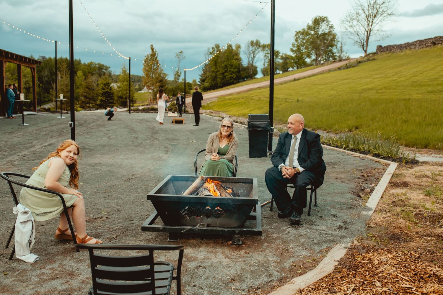 Outdoor wedding venue seating area with picnic tables and natural landscape.