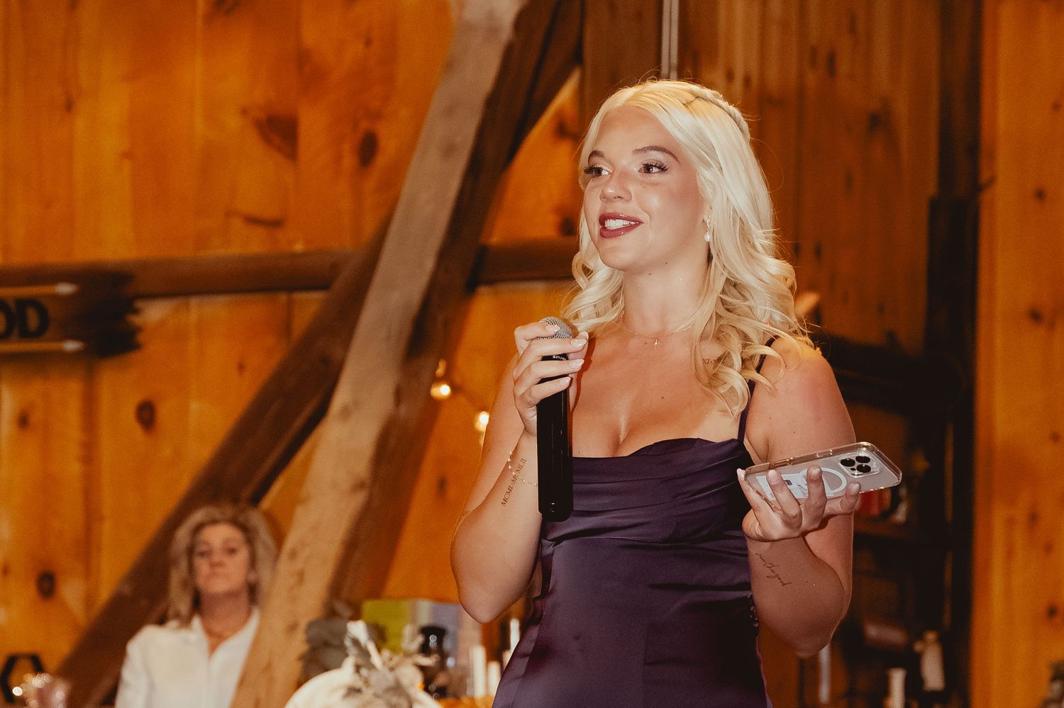 Wedding reception guests dancing and celebrating inside a rustic wooden barn venue.