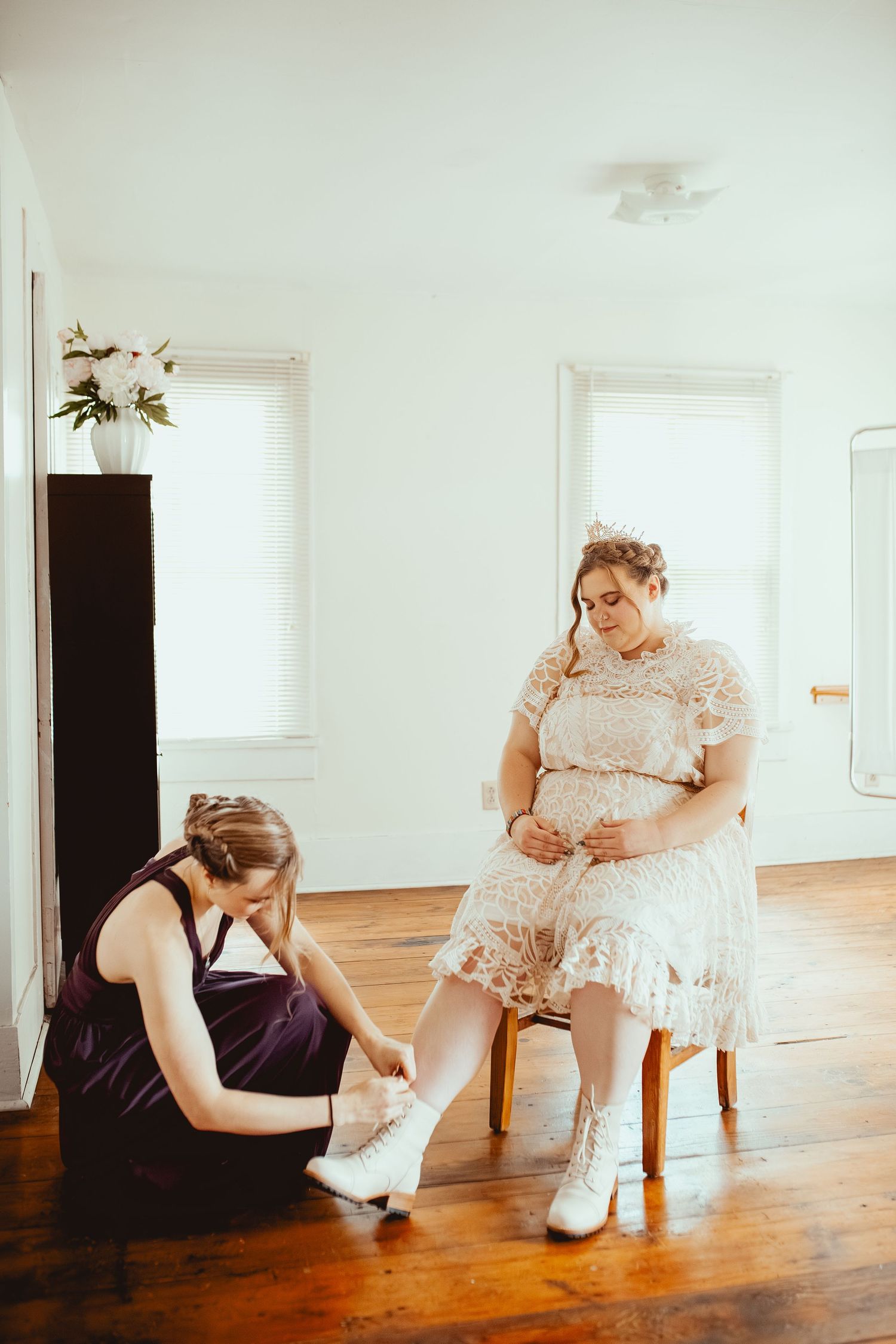 A series of artistic portraits showing someone in a white lace dress sitting on a wooden chair against a bright white wall.