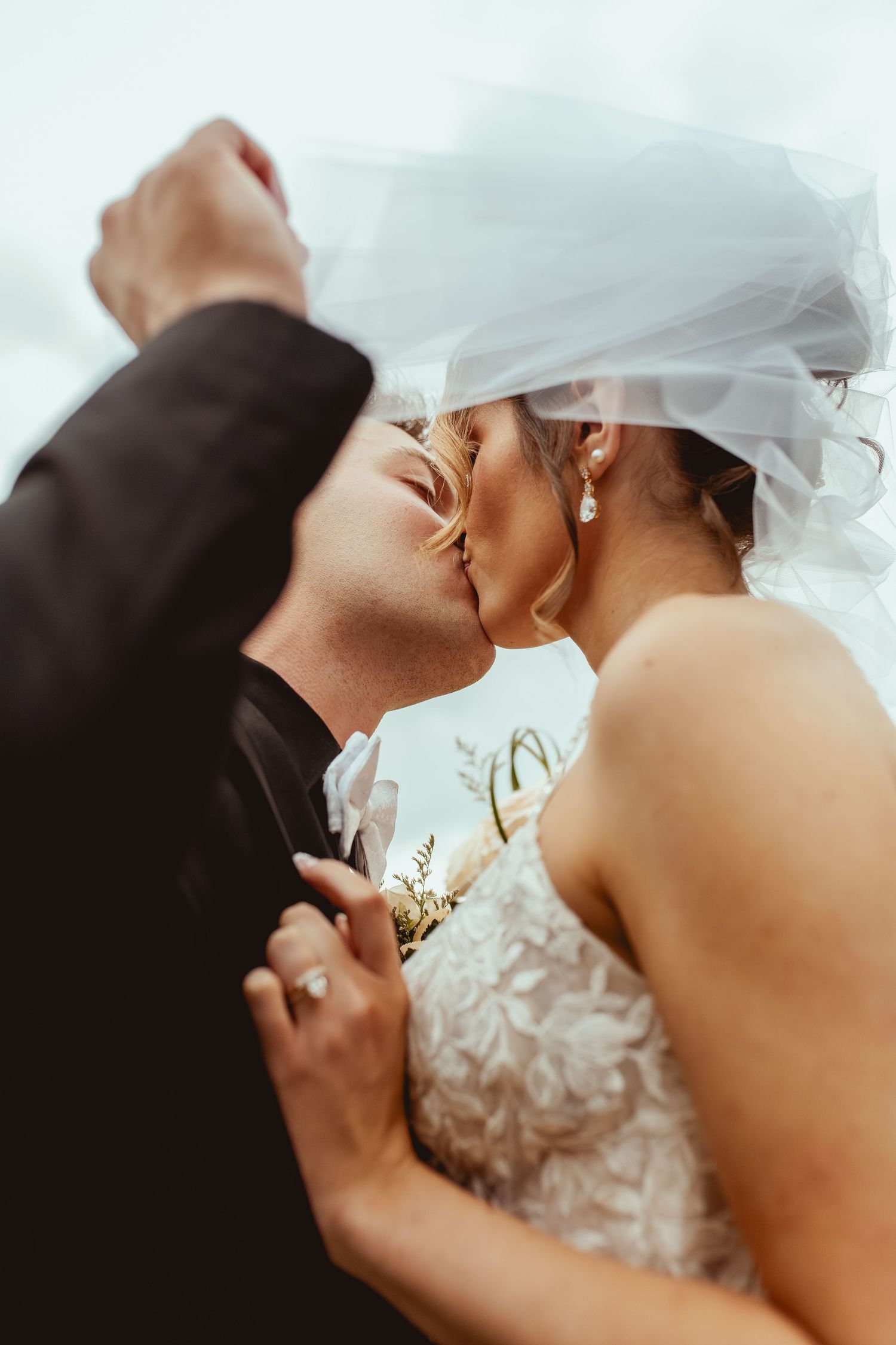 Close-up artistic sequence of a romantic wedding kiss with flowing white veil.