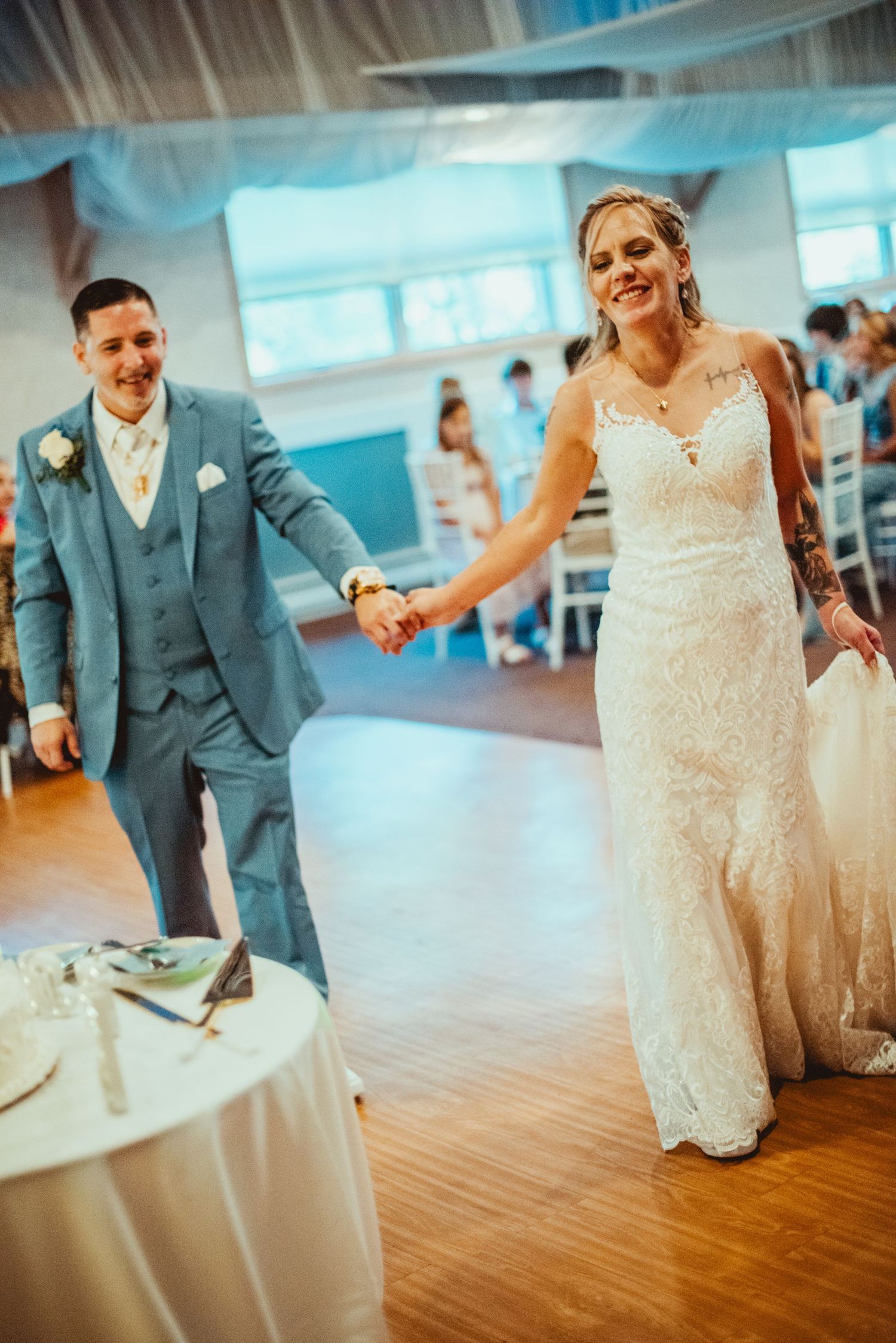 Newlyweds sharing a dance moment on wooden floor at indoor reception.
