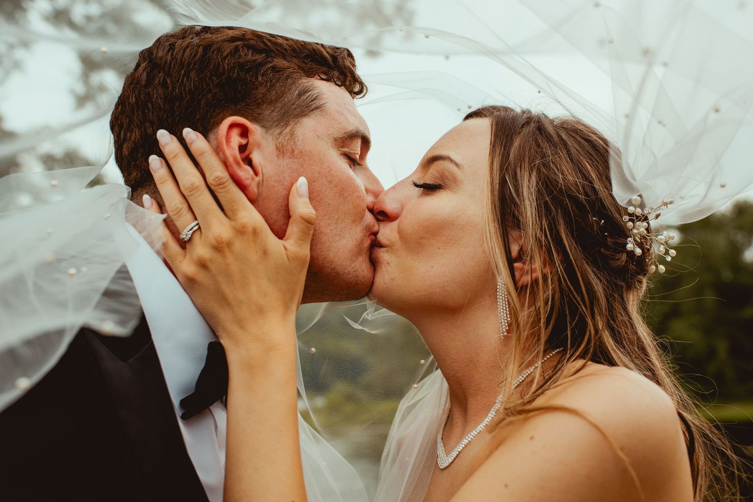 Romantic moment captured between newlyweds during golden hour at an outdoor venue.