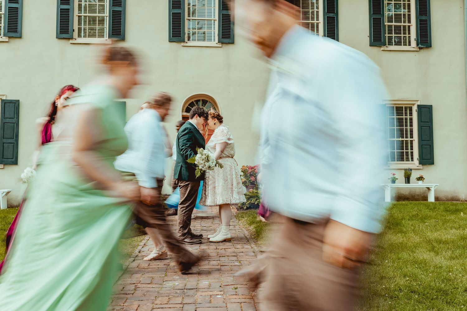 A series of motion-blurred photos showing people dancing and moving at an outdoor wedding celebration.