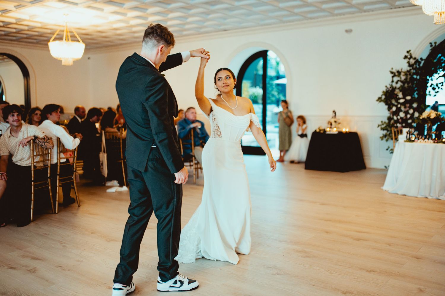 Wedding reception dance floor scene with guests celebrating in an elegant indoor venue.