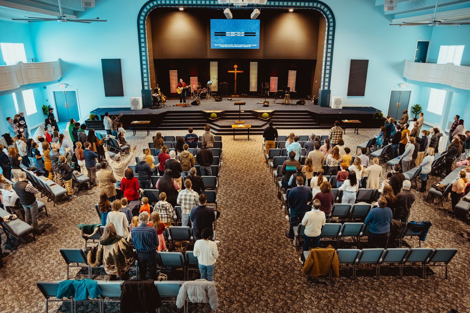 Large conference room filled with attendees seated in rows of chairs during an indoor event.