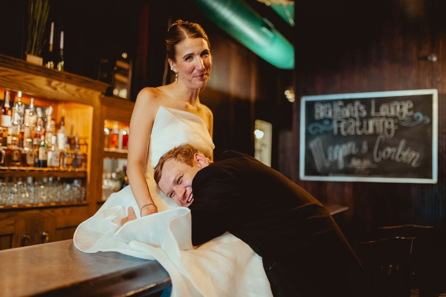 Wedding celebration at a cozy bar with chalkboard menu signs visible.