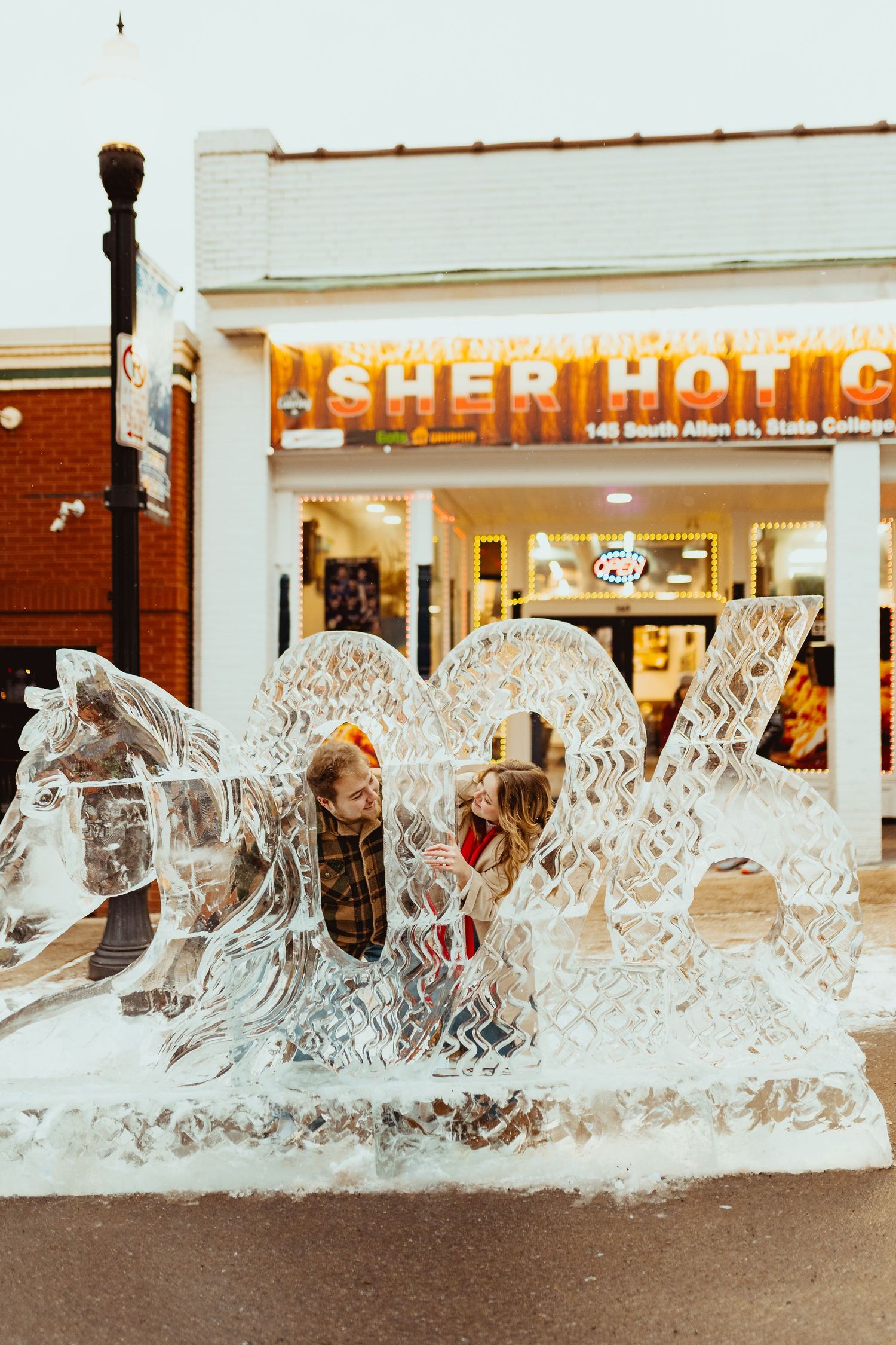 Decorative ice sculpture display outside a storefront with intricate carved details glinting in the light.