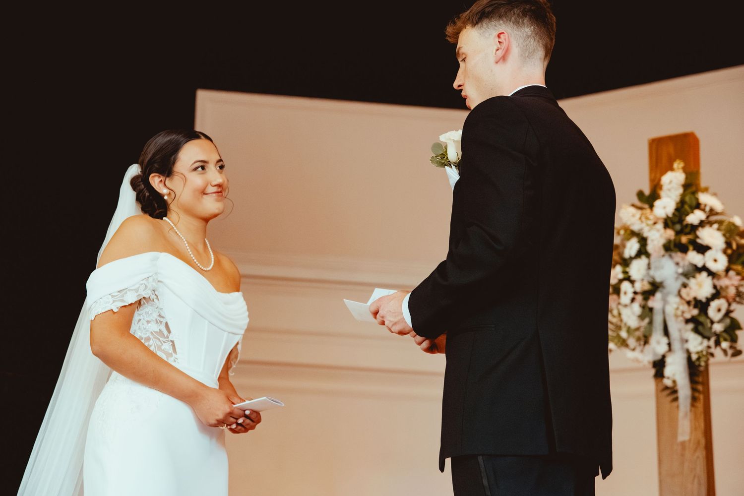 Wedding ceremony taking place with couple exchanging rings at the altar.