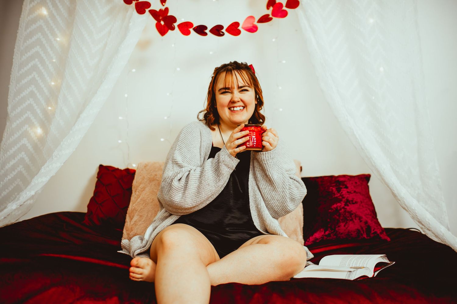 A string of red heart-shaped lights creates a festive Valentine's Day decoration against a white backdrop.