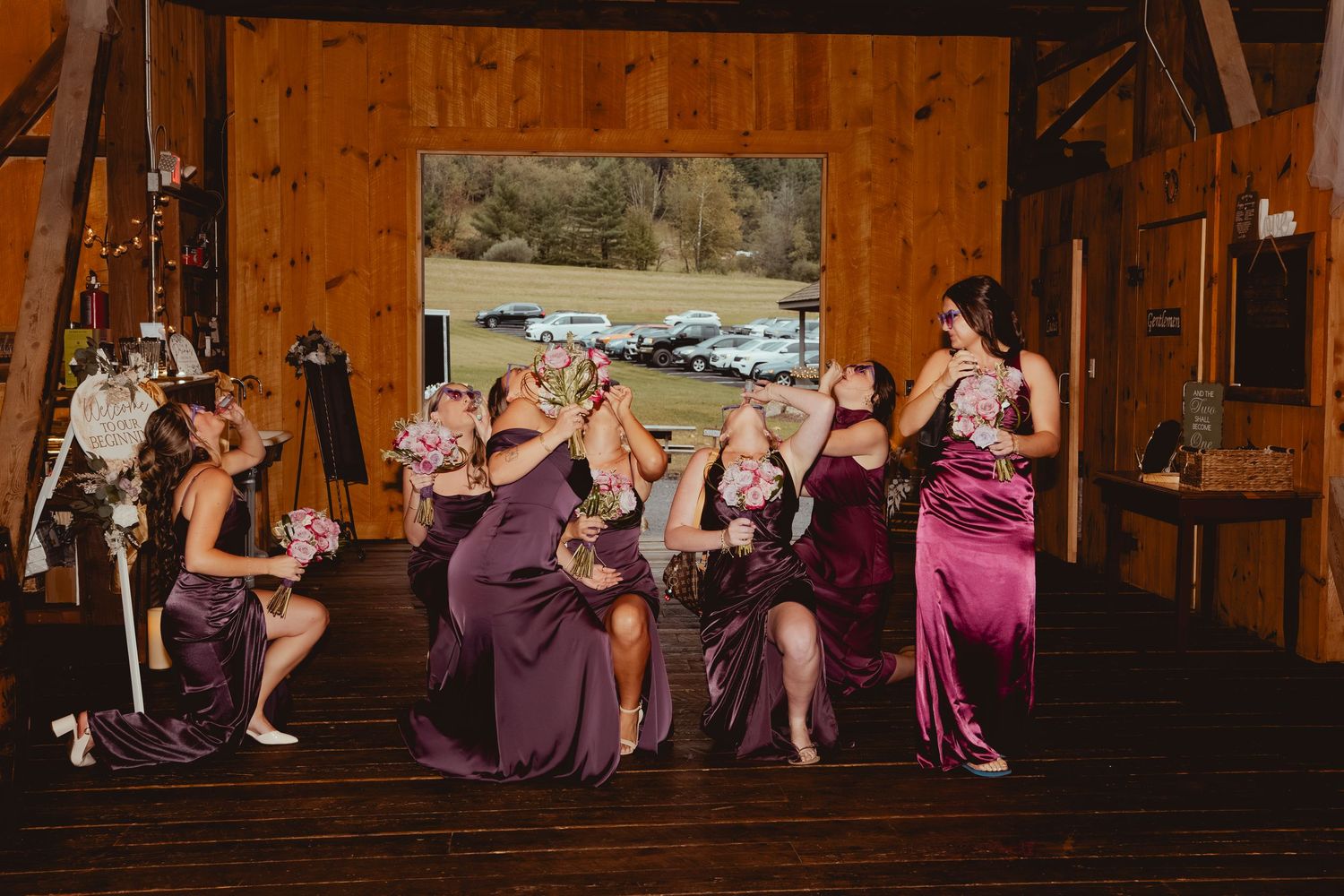 Wedding guests seated in rows at a rustic barn venue with wood paneled walls.