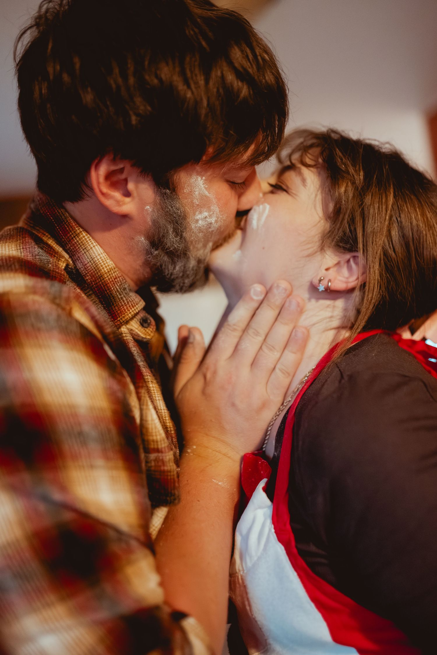 A romantic couple sharing an intimate moment in a warmly lit room.